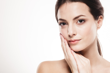 Young beautiful woman face portrait with healthy skin. Studio shot. Isolated on white.の写真素材