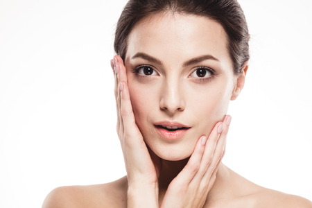 Young beautiful woman face portrait with healthy skin. Studio shot. Isolated on white.の写真素材