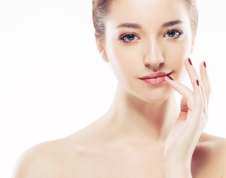 Young beautiful woman face portrait with healthy skin. Isolated on white. Studio shot.の写真素材