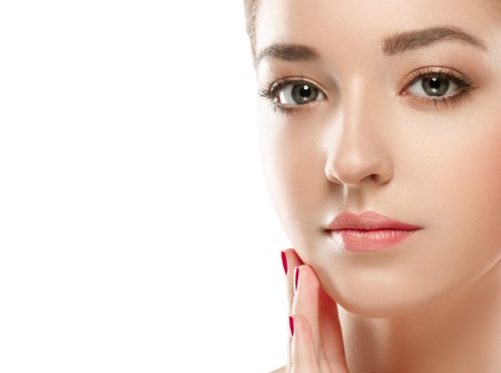 Young beautiful woman face portrait with healthy skin. Isolated on white. Studio shot.の写真素材