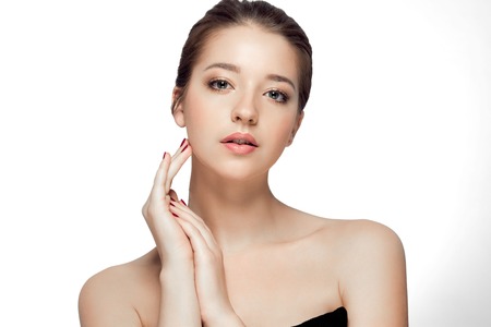 Young beautiful woman face portrait with healthy skin. Isolated on white. Studio shot.の写真素材