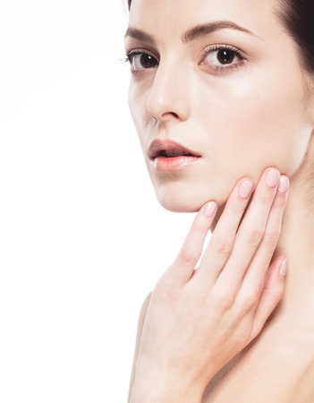Young beautiful woman face portrait with healthy skin. Studio shot. Isolated on white.の写真素材