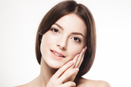 Young beautiful woman face portrait with healthy skin. Studio shot. Isolated on white.の写真素材