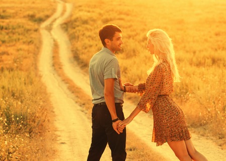 Beautiful and young couple in love together on summer field. Uptdoor shot.の写真素材