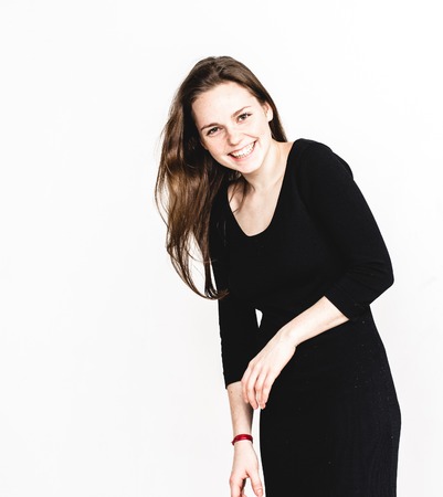 Woman portrait in black dress posing with long hair isolated on white.の写真素材