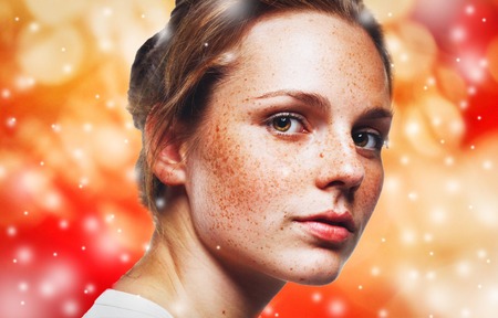 Woman portrait on lights snow and red background.の写真素材