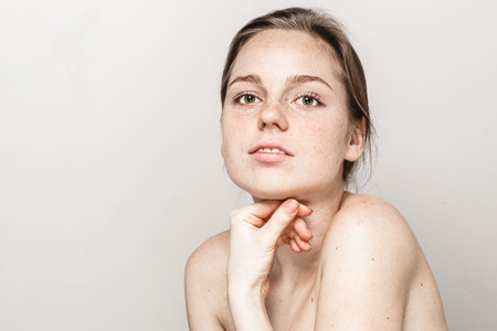 Young beautiful freckles woman face portrait with healthy skin.の写真素材