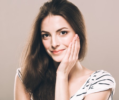 Beautiful young woman portrait touching her chinの写真素材