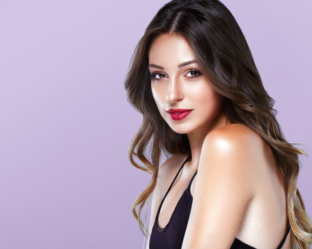 Beautiful Woman Skin Tanned Red Lips Healthy Beauty Skin Smile. Spa Beautiful Model Girl Cute Face over color background.の写真素材