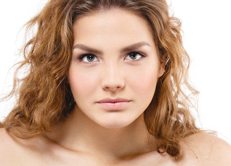 Young beautiful woman face portrait with healthy skin and curly hair. Studio shot. Isolated on white.の写真素材