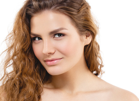 Young beautiful woman face portrait with healthy skin and curly hair. Studio shot. Isolated on white.の写真素材