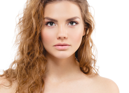 Young beautiful woman face portrait with healthy skin and curly hair. Studio shot. Isolated on white.の写真素材