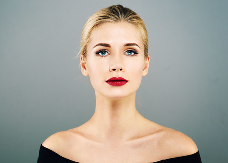 Beautiful Woman Blonde Hairstyle face with red lips portrait. Healthy skin and perfect makeup. Studio shot.の写真素材
