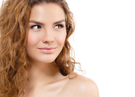 Young beautiful woman face portrait with healthy skin and curly hair. Studio shot. Isolated on white.の写真素材