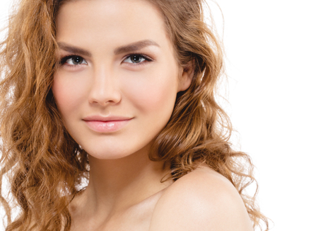 Young beautiful woman face portrait with healthy skin and curly hair. Studio shot. Isolated on white.の写真素材