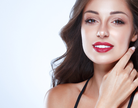Beautiful Woman Skin Tanned Red Lips Healthy Beauty Skin Smile. Spa Beautiful Model Girl Cute Face over color background.の写真素材