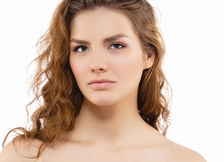 Young beautiful woman face portrait with healthy skin and curly hair. Studio shot. Isolated on white.の写真素材