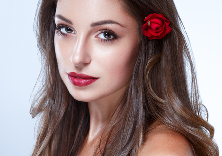 Beautiful Woman Skin Tanned Red Lips Healthy Beauty Skin Smile. Spa Beautiful Model Girl Cute Face over color background.の写真素材