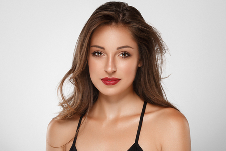 Beautiful Woman Skin Tanned Red Lips Healthy Beauty Skin Smile. Spa Beautiful Model Girl Cute Face over color background.の写真素材