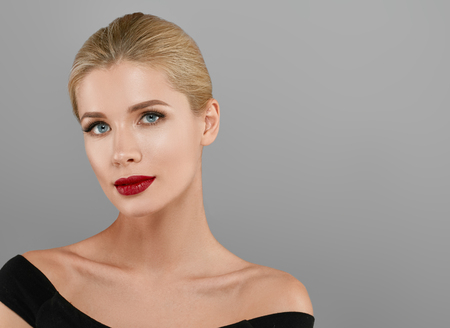 Blonde beautiful woman model over gray background. Woman nail manicure lipstick same color beauty portrait beautiful careの写真素材