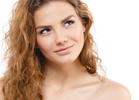 Young beautiful woman face portrait with healthy skin and curly hair. Studio shot. Isolated on white.の写真素材