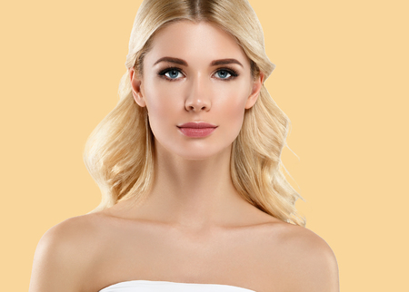 Beautiful girl face long curly blonde hair close up portrait young studio on yellow. Studio shot.の写真素材