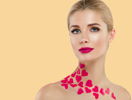 Beautiful woman Valentines Day Hearts concept. Blond Woman red lips over yellow background. Studio shot.の写真素材