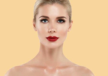 Beautiful woman face close up red lips lipstick studio on yellow. Studio shot.の写真素材