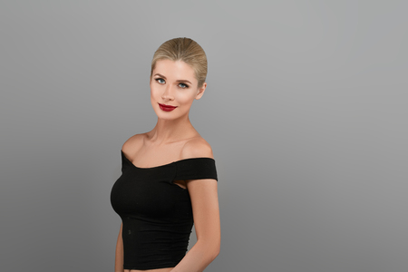 Blonde beautiful woman model over gray background. Woman nail manicure lipstick same color beauty portrait beautiful careの写真素材