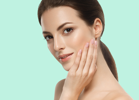 Beautiful girl hand touching face on summer green trendy color background. Studio shot.の写真素材