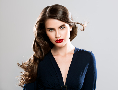 Beauty Woman face Portrait. Beautiful Spa model Girl with Perfect Fresh Clean Skin. Brunette female looking at camera and smiling on gray background. Beautiful hairstyle Youth and Skin Care Conceptの写真素材
