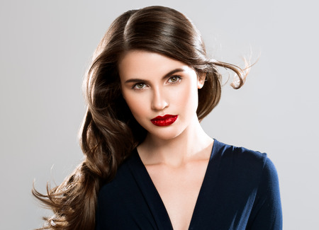 Beauty Woman face Portrait. Beautiful Spa model Girl with Perfect Fresh Clean Skin. Brunette female looking at camera and smiling on gray background. Beautiful hairstyle Youth and Skin Care Conceptの写真素材