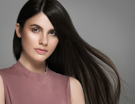 Beautiful perfect hair woman portrait. Studio shot. Gray background.の写真素材