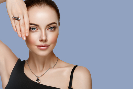 Beautiful Woman Portrait with Perfect makeup Hairstyle. Fashion Model jewelry over color background. Studio shot.の写真素材