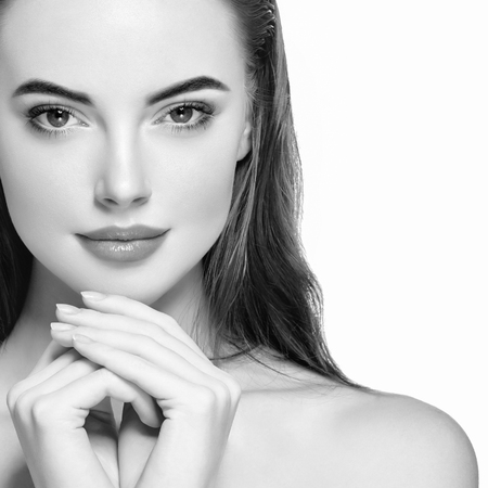 Woman face young beautiful healthy skin portrait with hands black and white. Studio shot.の写真素材