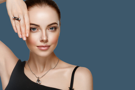 Beautiful Woman Portrait with Perfect makeup Hairstyle. Fashion Model jewelry over color background. Studio shot.の写真素材