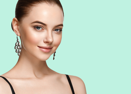 Beautiful girl on summer green trendy color background. Fashion Model jewelry. Studio shot.の写真素材