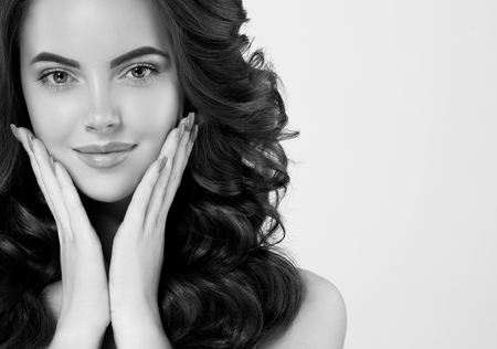 Woman face young beautiful healthy skin portrait with hands black and white. Studio shot.の写真素材