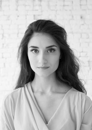 Young beautiful woman day light natural face portrait over brick wall black and white. Indoor shot.の写真素材