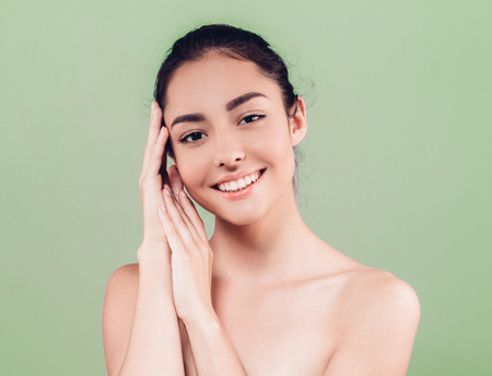 Beautiful Woman Face with hands Portrait Beauty Skin Care Concept. Fashion Beauty Model isolated on gray backgroundの写真素材