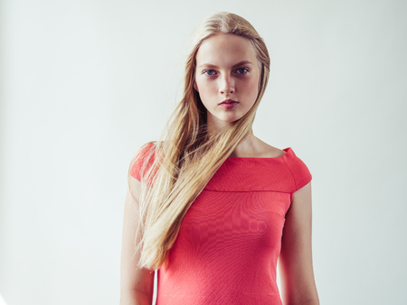 Beautiful long blonde hair woman in red dress natural over white background. Studio shot.の写真素材