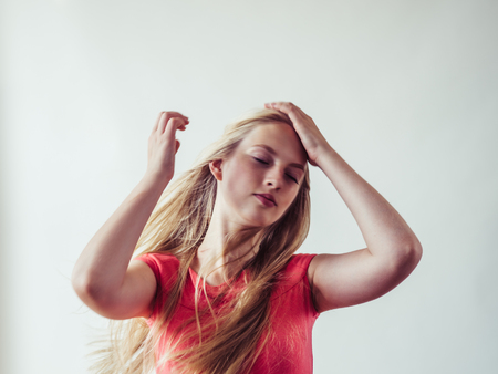 Beautiful long blonde hair woman in red dress natural over white background. Studio shot.の写真素材