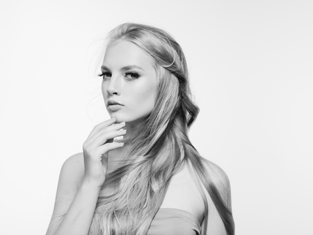 Blonde long hair woman beauty portrait with beautiful hairstyle isolated on white monochromeの写真素材