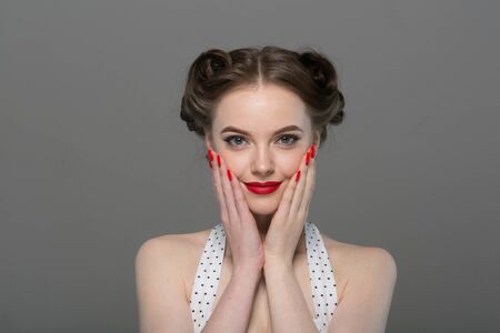Pin up woman portrait. Beautiful retro female in polka dot dress with red lips. Studio shot.の写真素材