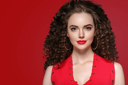 Beauty woman with rose flower beautiful curly hair and lips. Studio shot.の写真素材