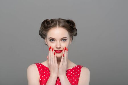 Pin up woman portrait. Beautiful retro female in polka dot dress with red lips. Studio shot.の写真素材