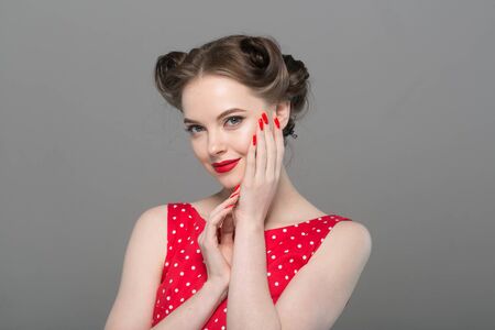 Pin up woman portrait. Beautiful retro female in polka dot dress with red lips. Studio shot.の写真素材