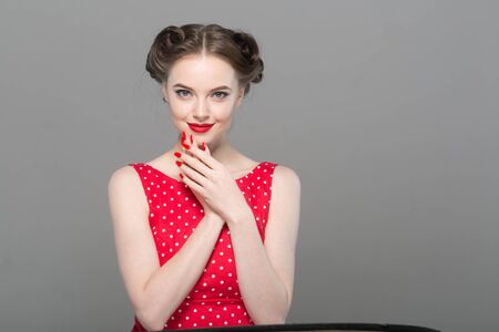 Pin up woman portrait. Beautiful retro female in polka dot dress with red lips. Studio shot.の写真素材