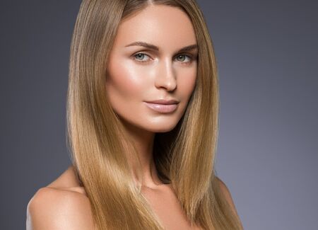 Beauty woman face healthy beautiful skin and blond smooth hair. Studio shot.の写真素材