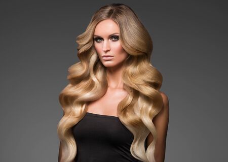 Blond woman long hair curly natural fashion makeup. Studio shot.の写真素材